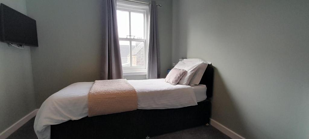 a bed in a room with a window at The Anchorage in Saint Margarets Hope