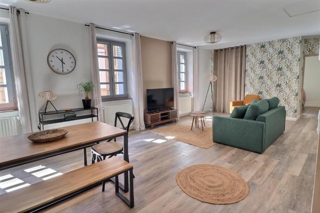 un salon avec un canapé vert et une table dans l'établissement Chez Nel, à Figeac