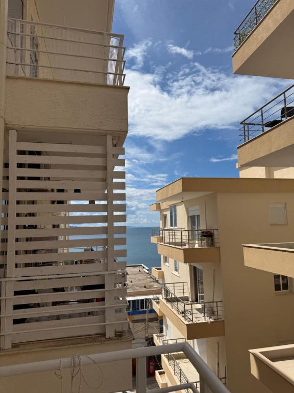 a view of the ocean from the balcony of a building at Mateos Apartment Saranda in Sarandë