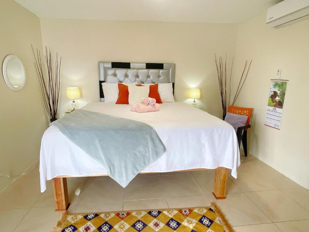a bedroom with a large bed with a pink stuffed animal on it at Skyline Suites Villa and Spa in Montego Bay