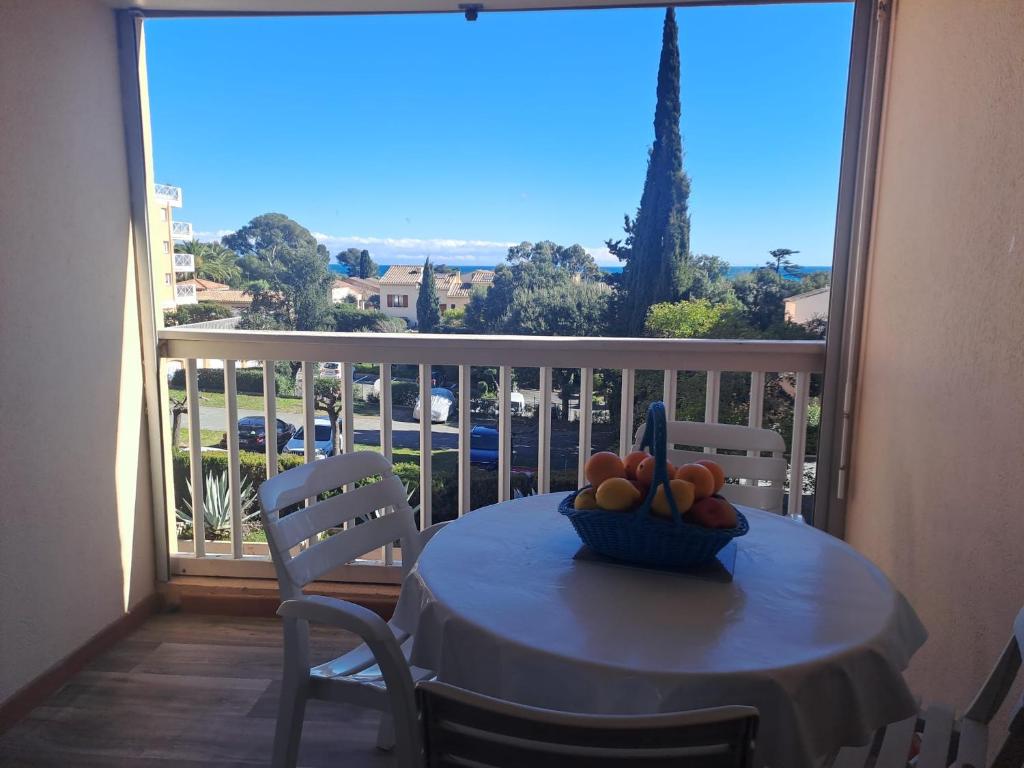 une table avec un bol de fruits sur un balcon dans l'établissement Charmant T2 avec Terrasse à Saint Aygulf - Idéal pour 3 personnes, à Fréjus