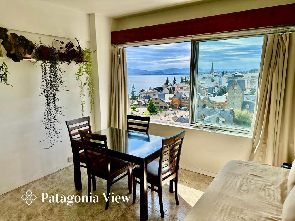 Un comedor con mesa y sillas y una gran ventana. en Patagonia View, en San Carlos de Bariloche