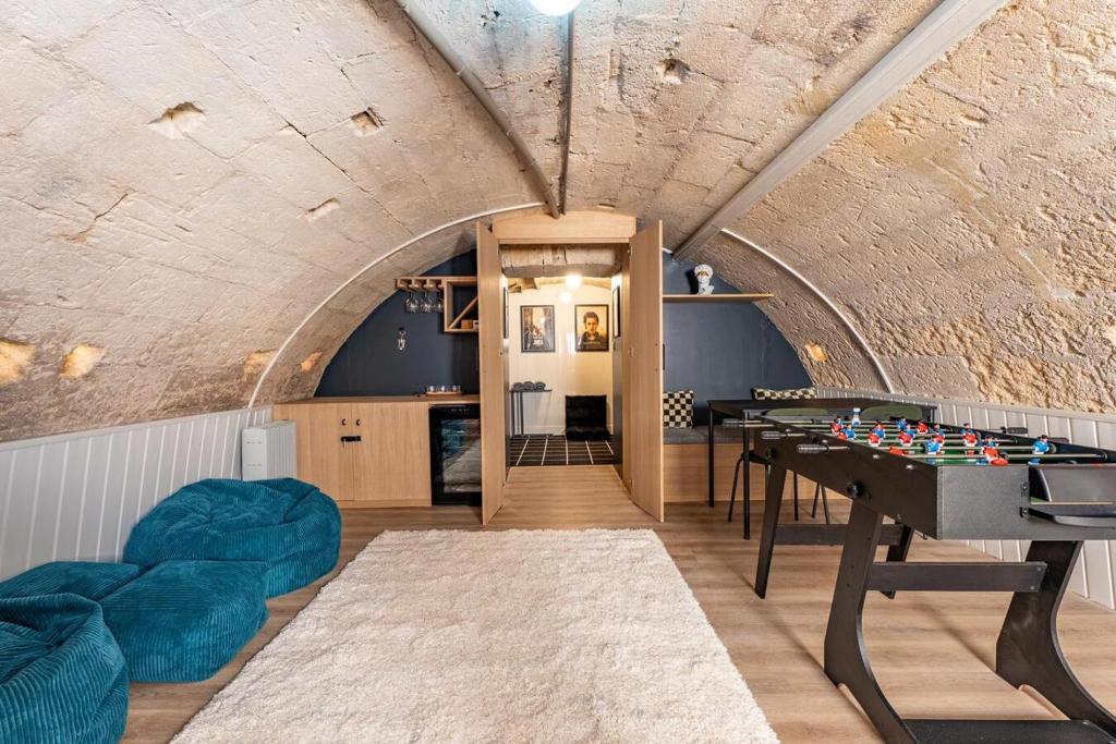 a room with a ping pong table in the middle of a tunnel at L'ARCADE SECRETE Appartement climatisé, Jacuzzi, Borne d'arcade Bordeaux centre in Bordeaux
