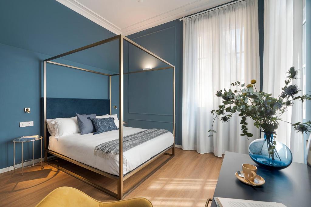 una camera blu con letto a baldacchino di Elysium Boutique Apartments - Catania a Catania