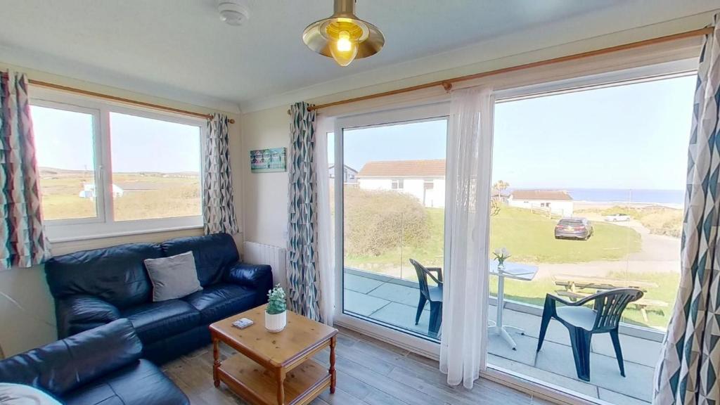 a living room with a couch and a large window at D20 Glendon, Riviere Towans in Hayle