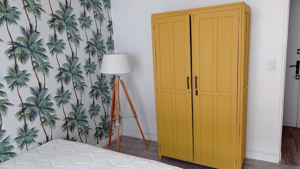 une chambre avec une armoire jaune et un mur dans l'établissement Appartement rénové hypercentre plage à 5 minutes à pied, à Saint-Nazaire