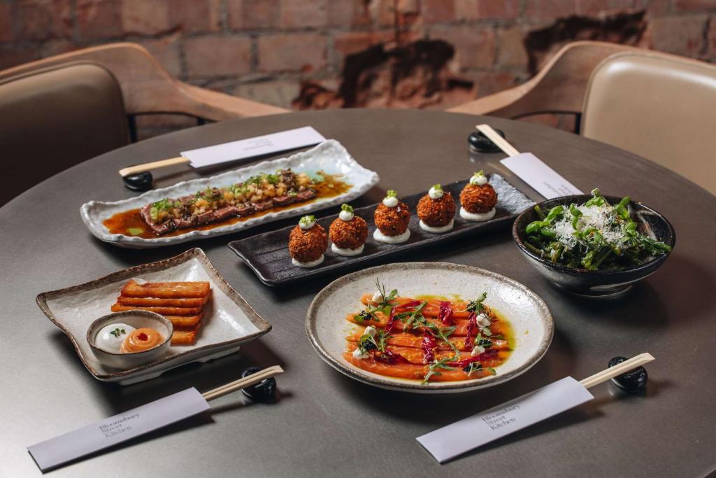 a table with plates of food on a table at Radisson Blu Hotel, London Bloomsbury in London