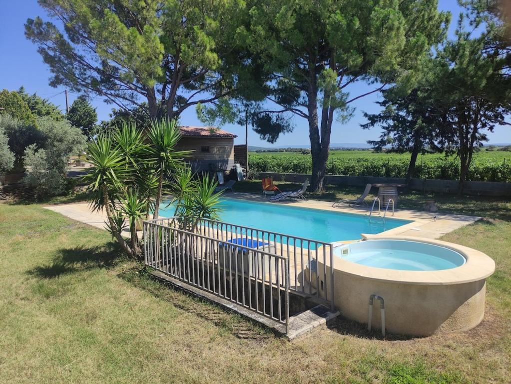 - une piscine dans une cour entourée d'une clôture dans l'établissement Maison d'hôtes avec piscine en juillet et août, à Châteauneuf-du-Pape