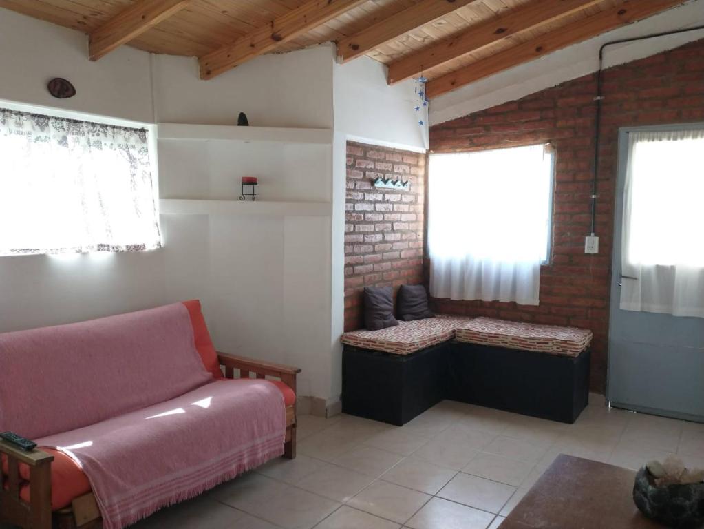a living room with a couch and two windows at Lo de Nelly 1 in Puerto Madryn