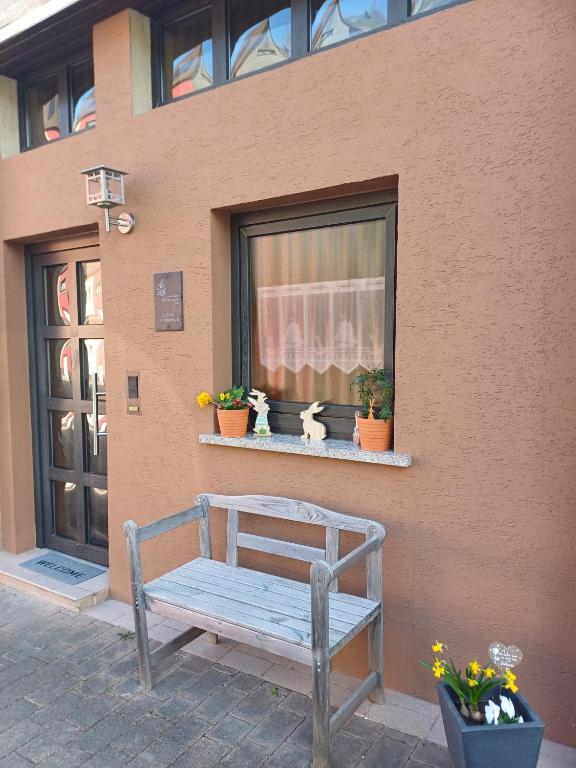 a wooden bench sitting outside of a window at Gutheils-Ferienwohnung in Nanzdietschweiler