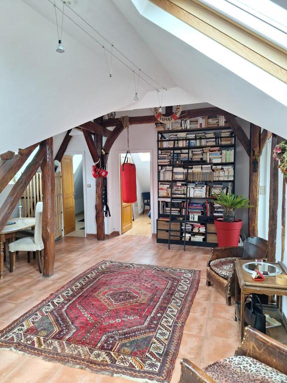 - un salon mansardé avec un tapis au sol dans l'établissement Les toits de Mantes, à Mantes-la-Jolie