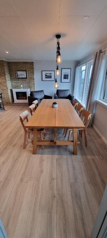 a dining room with a wooden table and chairs at Apartment- fjord view, big terrace, close to Moa in Ålesund