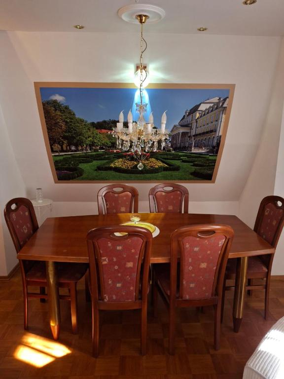 a dining room table with chairs and a painting on the wall at VILLA GOLF Crystal Drop Apartment in Rogaška Slatina