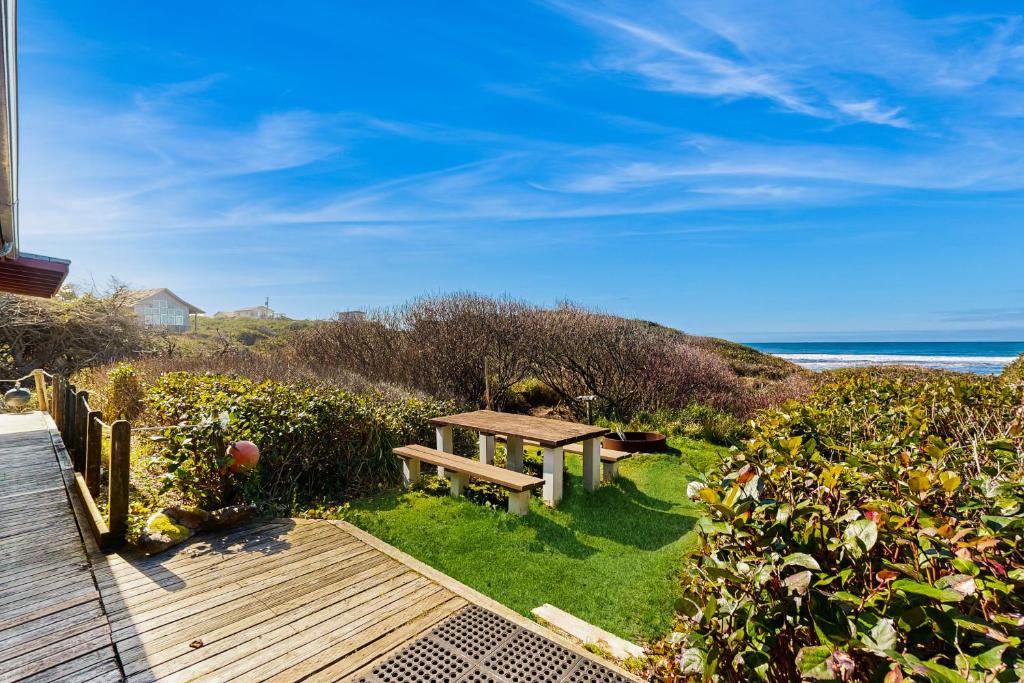 a bench sitting on the grass near the beach at Dulcinea's Cabin in Yachats