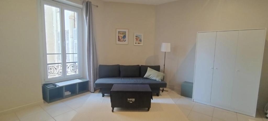 un salon avec un canapé bleu et une fenêtre dans l'établissement Studio near center, à Nice