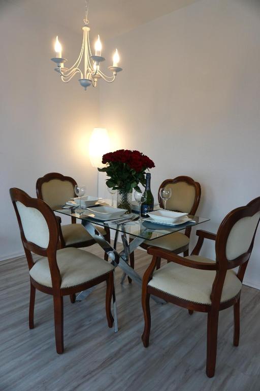 a dining room table with two chairs and a vase of flowers at Apartment Miesmuschelparadies in Lübeck
