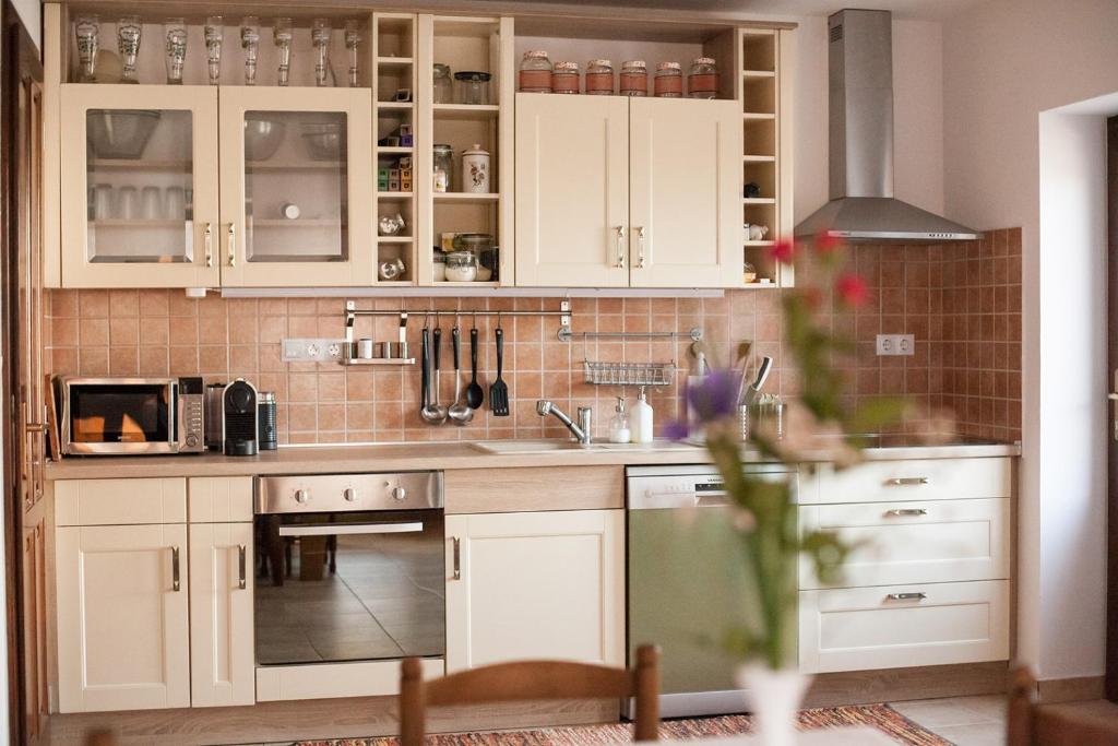 a kitchen with white cabinets and a stove top oven at Maushaus in Véménd