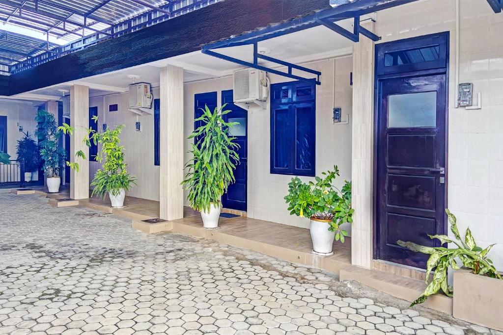 une maison avec des plantes en pot devant une porte dans l'établissement Hotel O Mariko's House, à Kupang