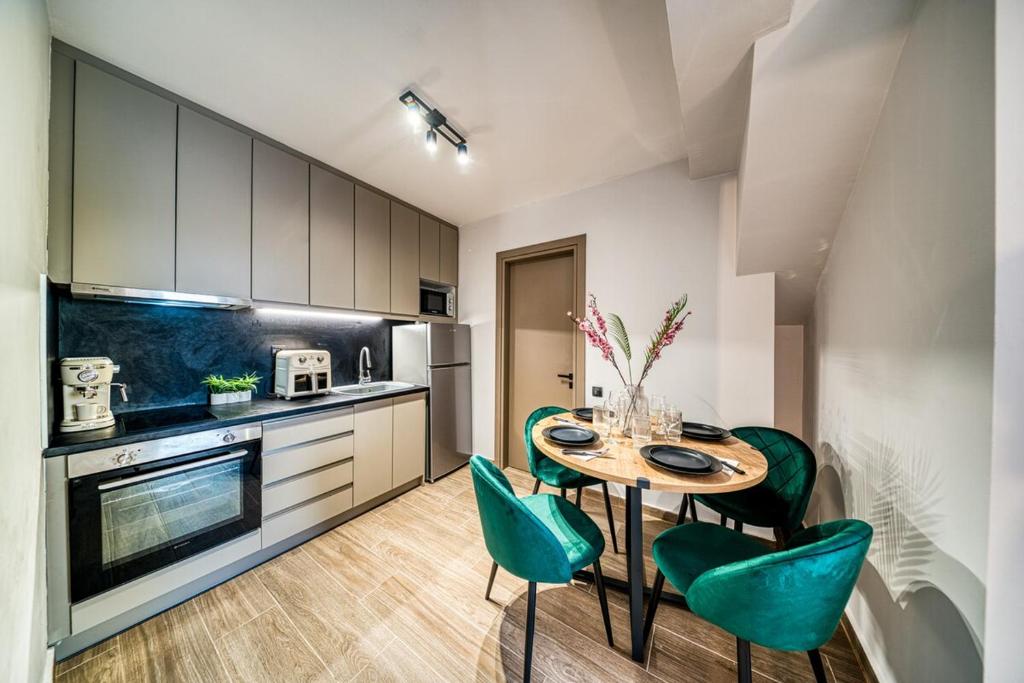 a kitchen with a table and green chairs at Windmill Escape Apartments B in Chios