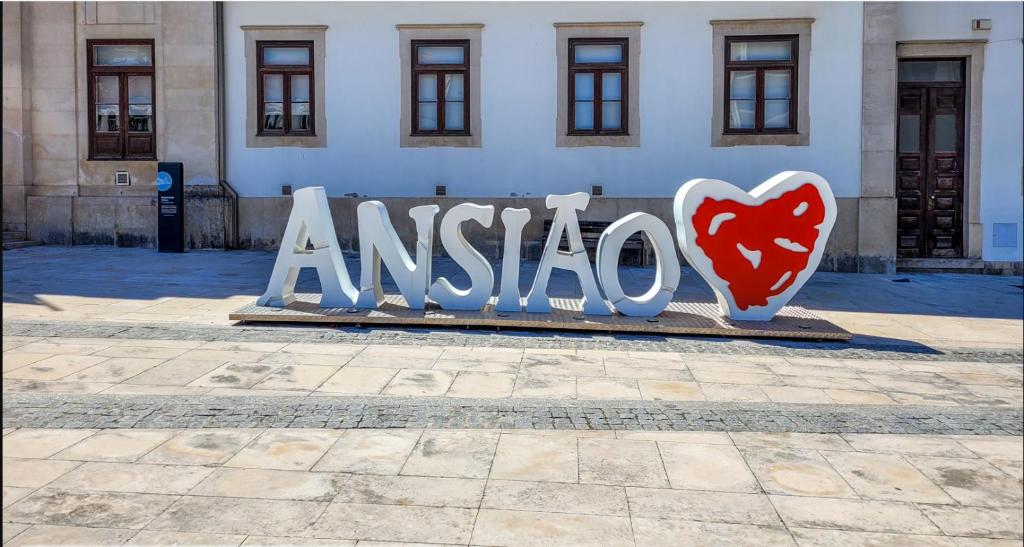 a sign with a heart on it in front of a building at T1TR Anciao in Ancião