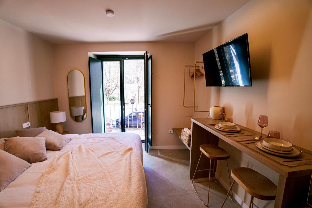 a bedroom with a bed and a desk with a television at Vista Verde in Cuenca