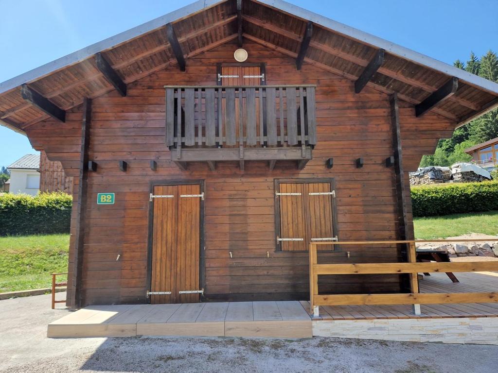 a small wooden building with a balcony and a bench at Chalet des FURETS in Xonrupt-Longemer