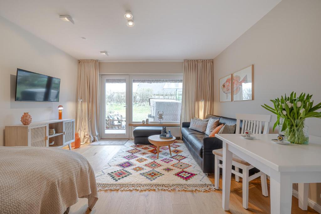 ein Wohnzimmer mit Sofa und Tisch in der Unterkunft Kleine Perle in Kampen