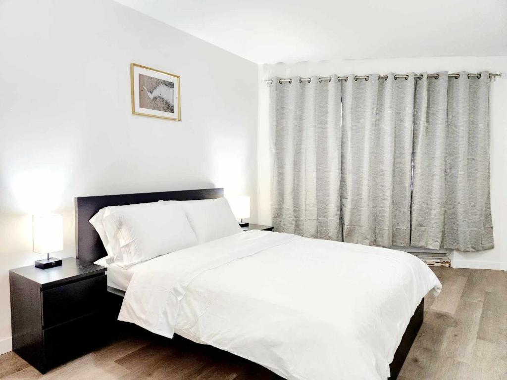 モントリオールにあるAPARTMENT HOTEL ST-DENISの白いベッドと窓のある寝室
