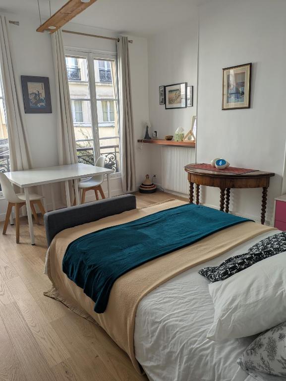 une chambre avec un grand lit et une table dans l'établissement Charming apartment - famous Marais neighborhood, à Paris