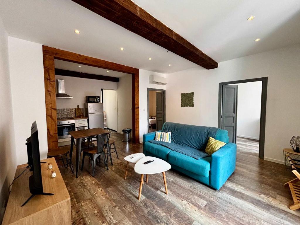 un salon avec un canapé bleu et une table dans l'établissement Casamea - Rue Fesch, Famille, Wifi, Clim, à Ajaccio