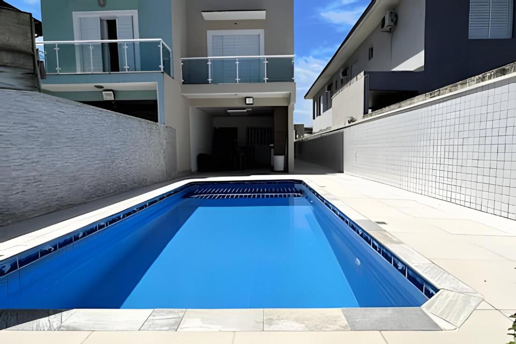 Casa c/ piscina em Cond, Boraceia - SP في بوراسيا: حمام سباحة أزرق كبير أمام مبنى