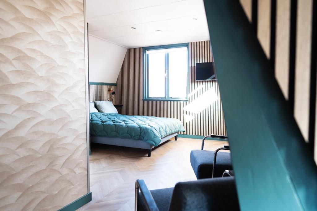 un dormitorio con una cama y un espejo en 1 aan Strand, en Egmond aan Zee