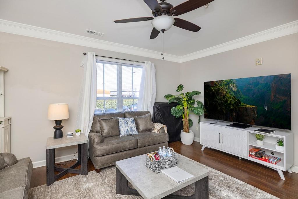 een woonkamer met een bank en een flatscreen-tv bij King and Queen Beds with a Gourmet Kitchen in Charlotte