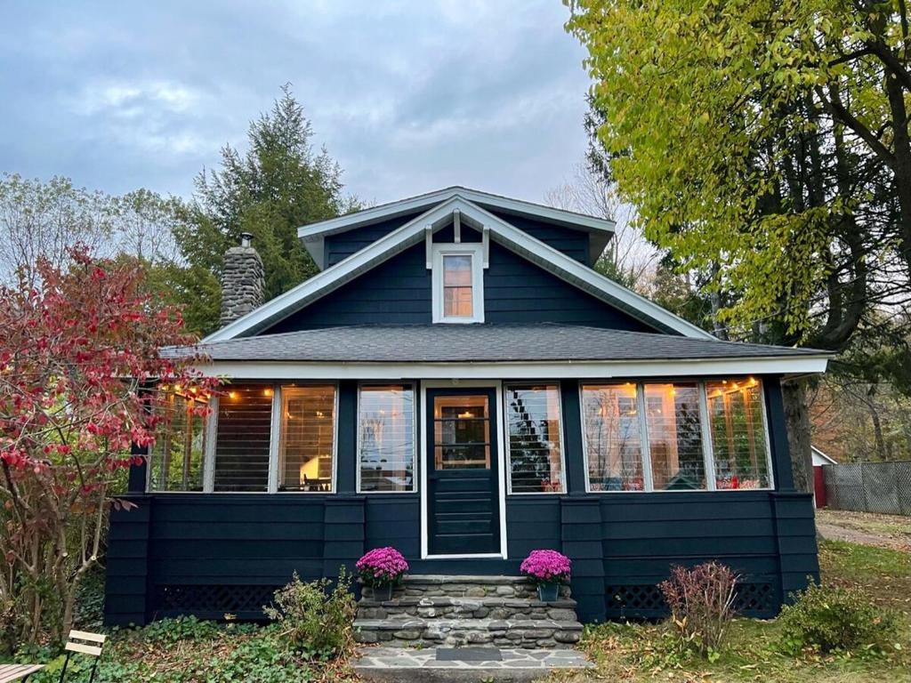 a blue house with a front porch and flowers at Phoenicia Bungalow in Phoenicia