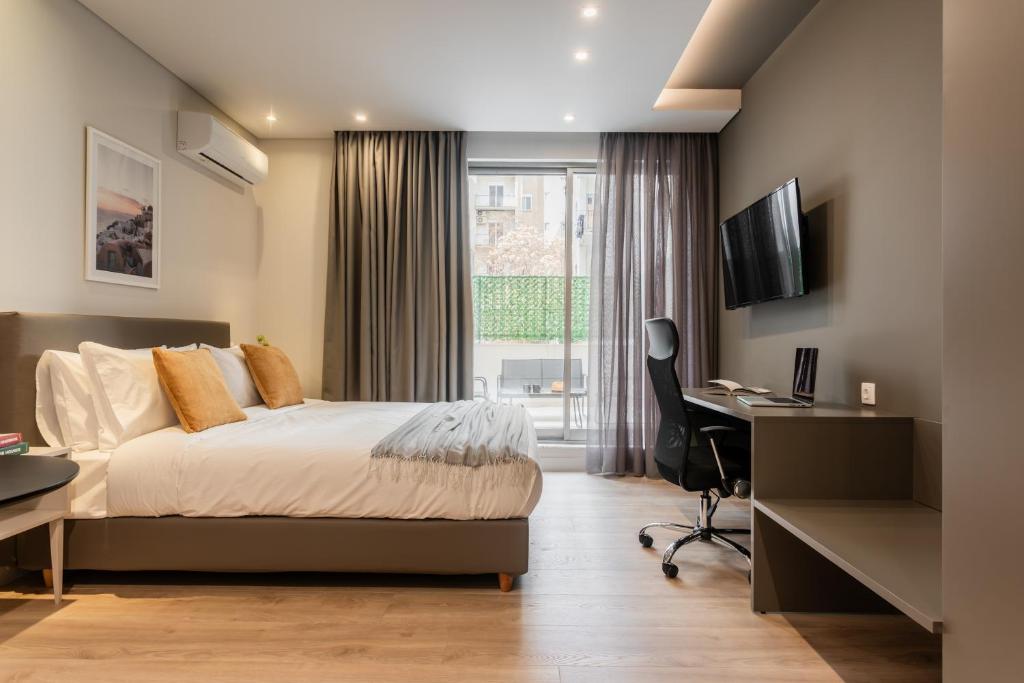a bedroom with a bed and a desk and a window at WYZ Museum by UPSTREET in Athens