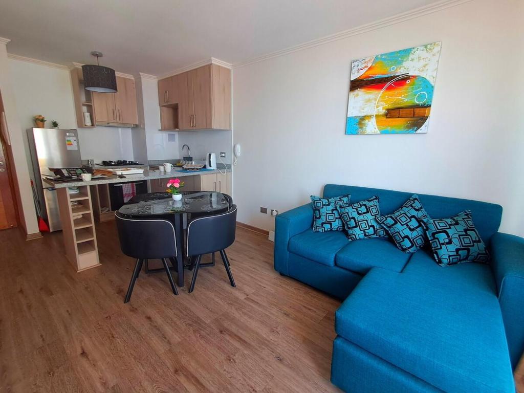 a living room with a blue couch and a table at Hermosa vista al mar dpto Sec Sur Llacolen-Estac- Piscina in Antofagasta