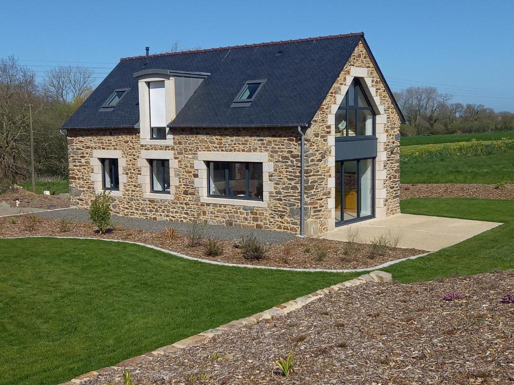 ein Steinhaus mit schwarzem Dach in der Unterkunft Maison Beniguet 6 places proche Paimpol et Tréguier in Pleumeur-Gautier