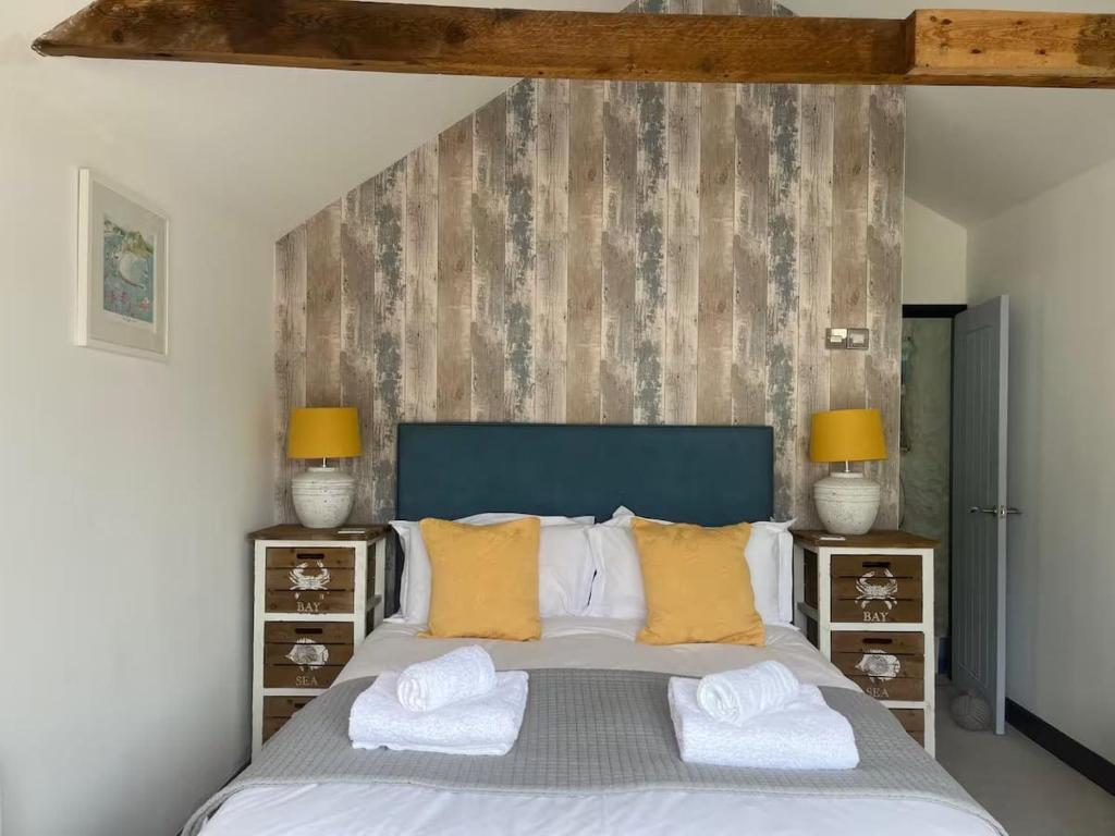 Un dormitorio con una cama grande con almohadas amarillas. en Beautiful Quayside Cottage Looe, en Looe