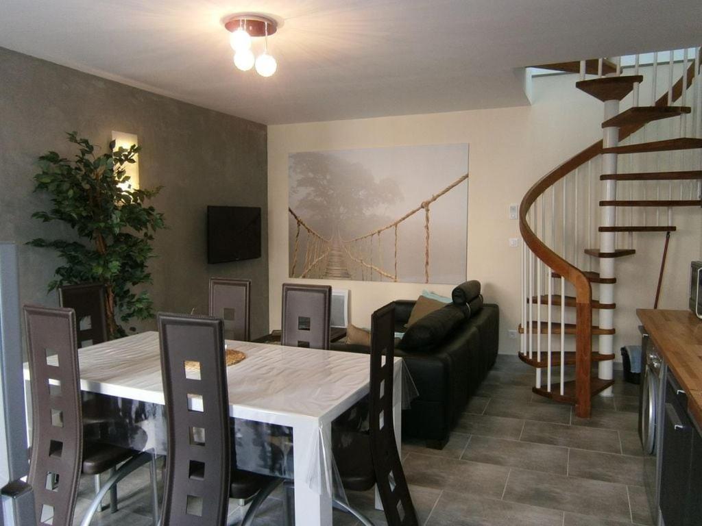 une salle à manger avec une table et un tableau de pont sur le mur dans l'établissement Gîte les Onagres 2 Le Crotoy, à 2 minutes de la plage, au Crotoy