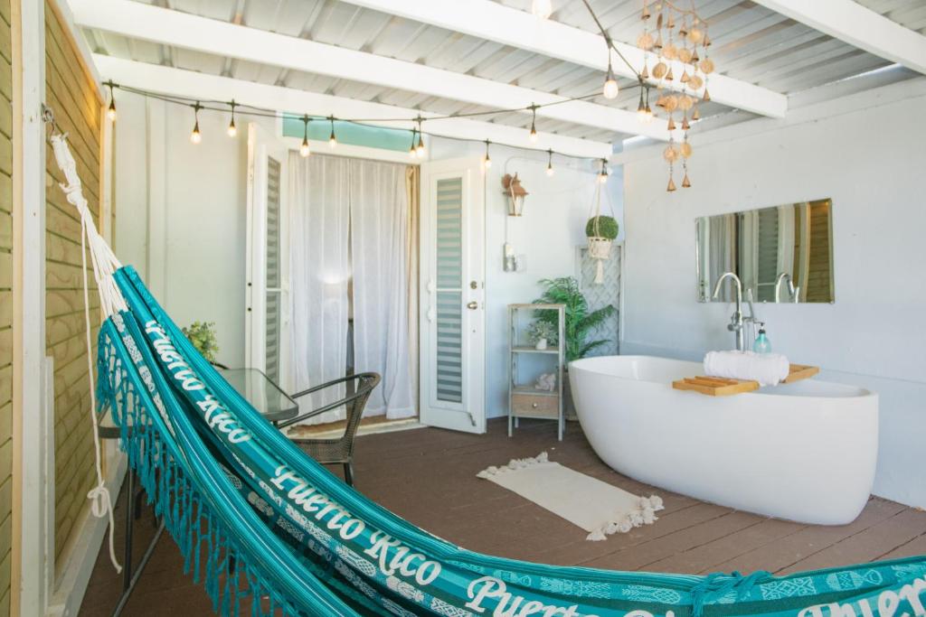 a bathroom with a tub and a hammock in it at Casa Loba Suite 1 with an outdoor tub in Rincon