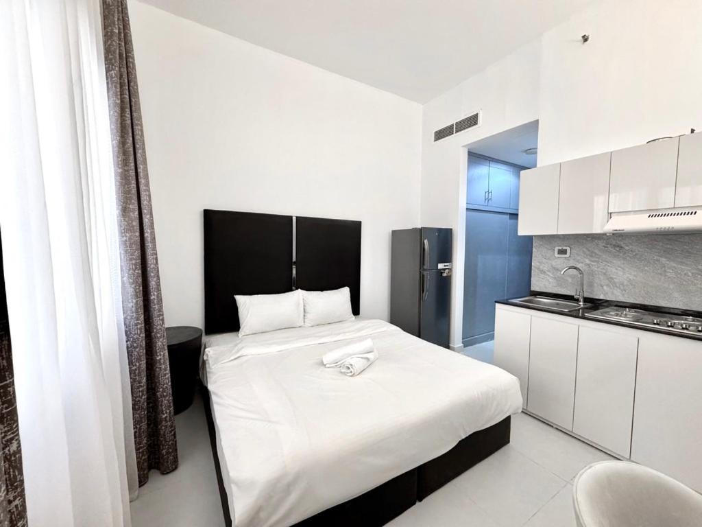 a bedroom with a large white bed in a room at Al Manara Classic Deluxe Studio in Dubai