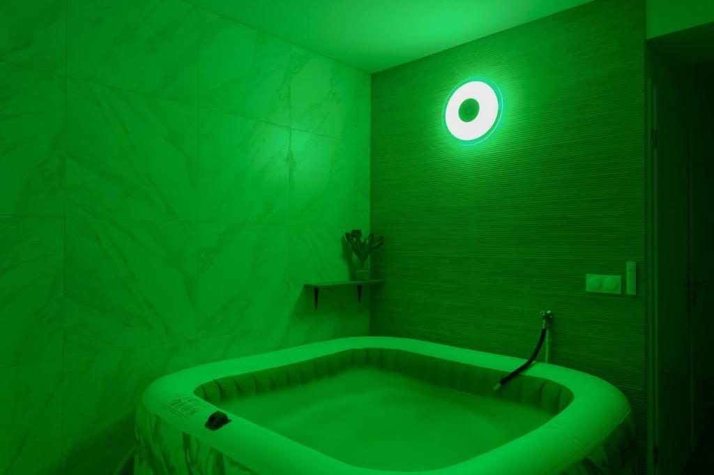 a green bathroom with a tub with a green light at Grand F2 de 50m2 pour 4 personnes - Paris 10eme Gare du Nord, Stade de France in Saint-Denis