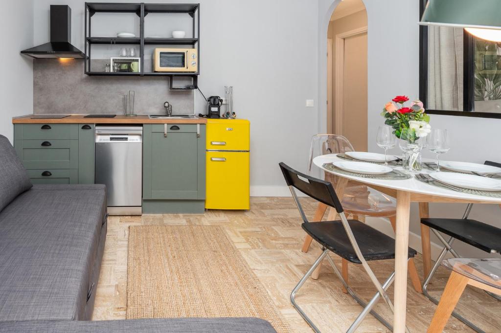 une cuisine avec une table et une armoire jaune dans l'établissement Les tennis, à Roquebrune-Cap-Martin