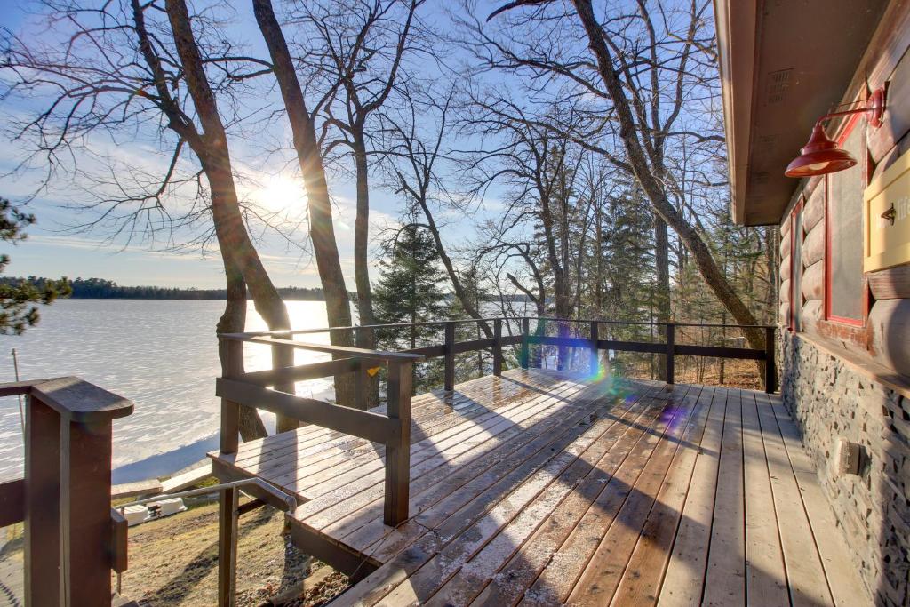 a wooden deck with a view of a lake at Cozy Cabin with Private Dock on Fifth Crow Wing Lake in Nevis