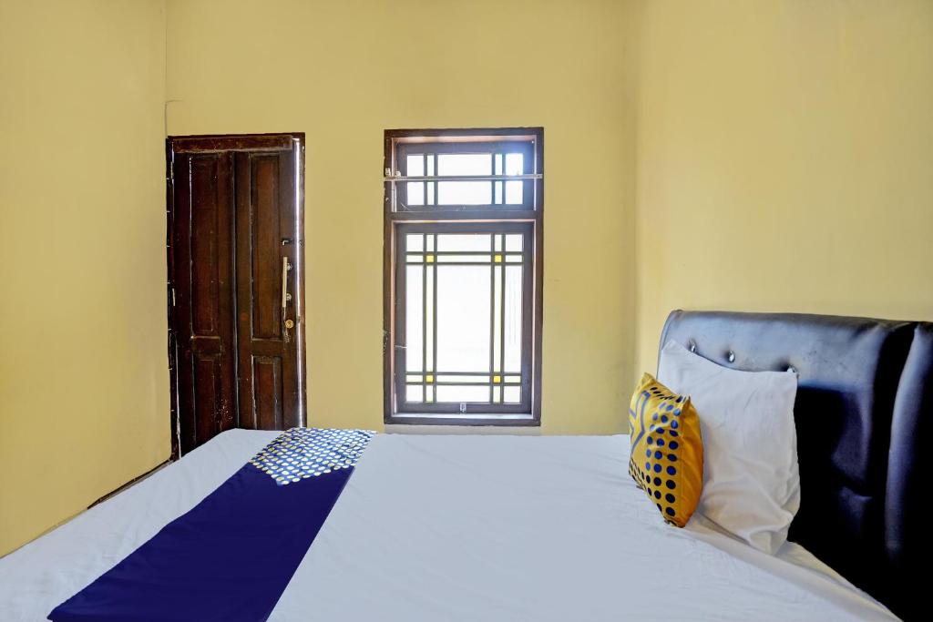 a bedroom with a large bed and a window at SPOT ON 92475 Rc Homestay Syariah in Banyuwangi