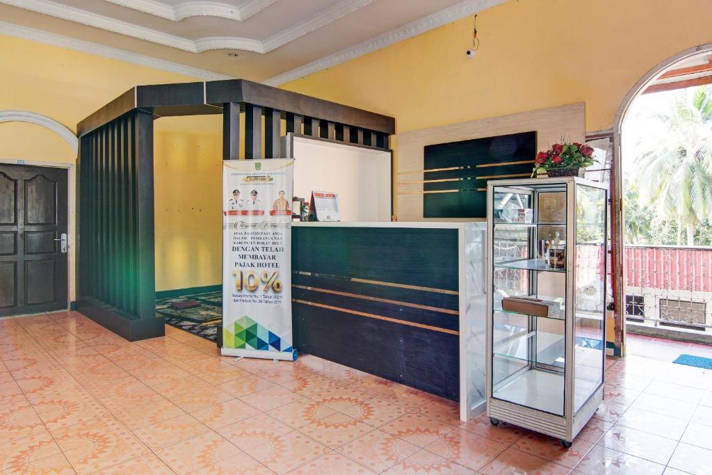 a kitchen with a counter and a refrigerator at OYO 92497 Penginapan Pasir Indah SyariahNearMonument Park City Sand Pengaraian in Pasirpengarayan