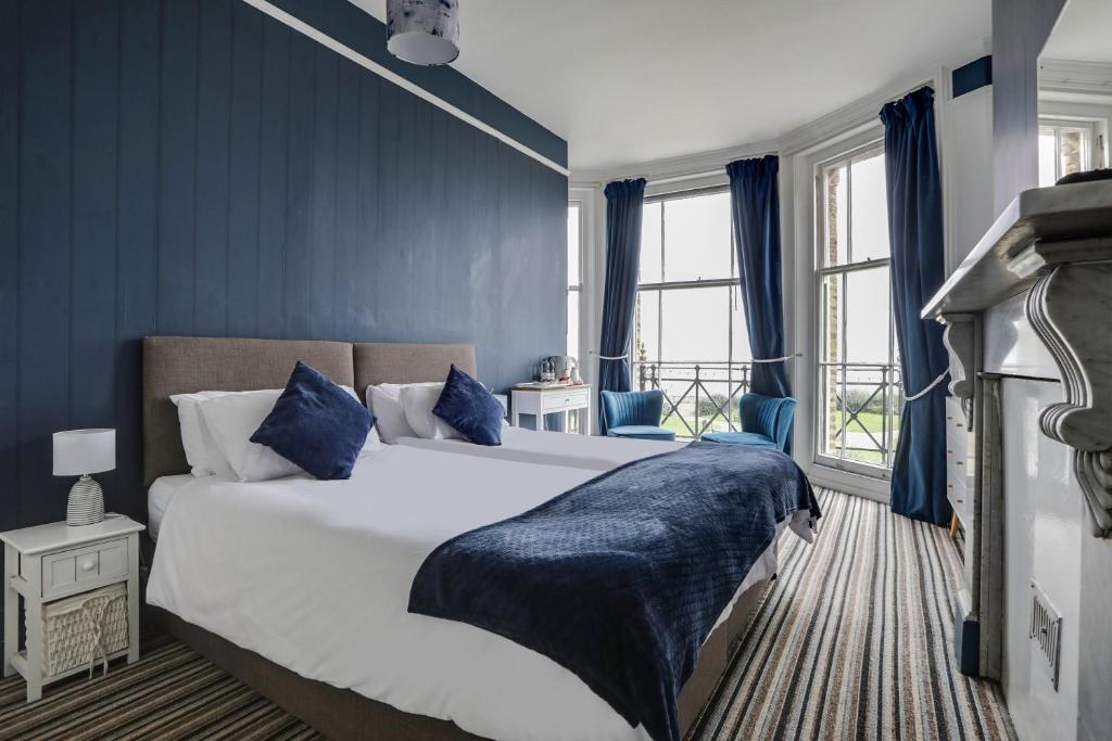 a bedroom with a large bed with blue walls at Lord Kitcheners Guest House in Lowestoft