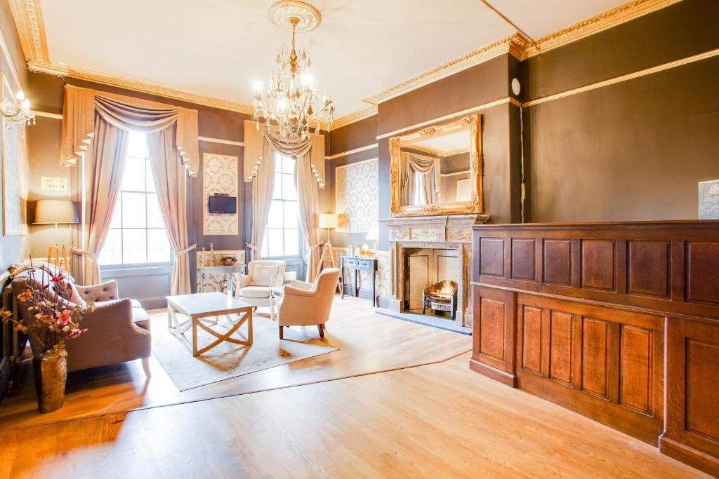 a living room with a fireplace and a chandelier at The Somerset Baker Street London in London