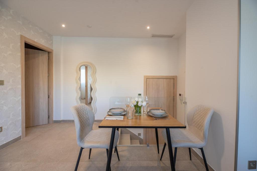 una sala da pranzo con tavolo e sedie in legno di NUBA apartamentos turísticos a Monforte de Lemos