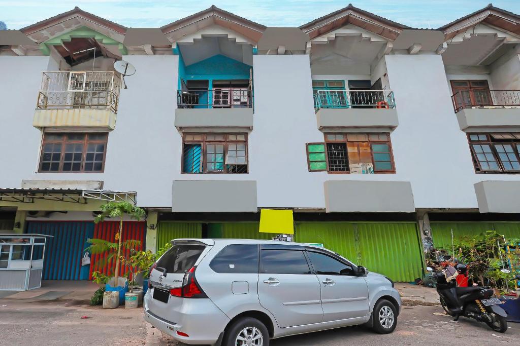une camionnette en argent garée devant un bâtiment dans l'établissement Hotel O Joyoakis Homestay SyariahNearMall Nagoya Hill, à Nagoya